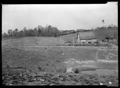Close-up of site for proposed garden and poultry center. The pond in the foreground is artifical. Note the rocky... - NARA - 532799