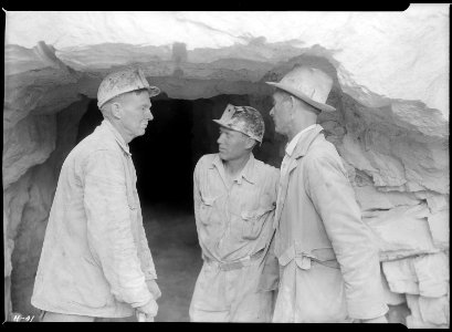 Foreman Clark and two of the shaftmen, Arthur Roberts and Sam Mynatt, at the mouth of the test tunnel at Norris Dam... - NARA - 532665 photo