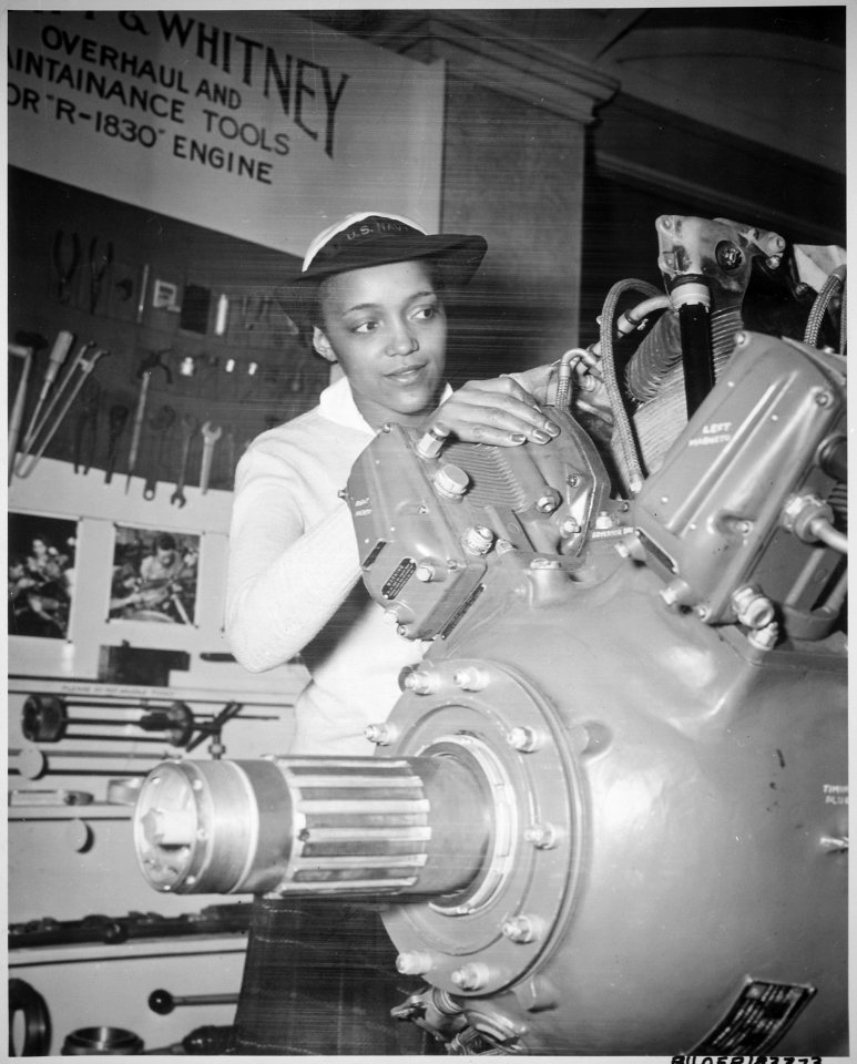 Inspecting a Grumman Wildcat engine on display at the U.S. Naval Training School (WR) Bronx, NY, where she is a `boot' - NARA - 520638