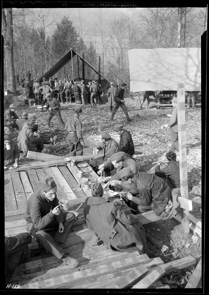 Lunch time at CCC Camp, TVA ^22, near Esco, Tennessee. The crowd around the cook tent in the left background is... - NARA - 532777