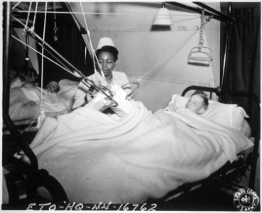 Lt. Florie E. Gant...tends a patient at a prisoner-of war hospital somewhere in England., 10-07-1944 - NARA - 531495 photo