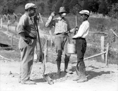 Water boy and two workers on the roadway to Norris Dam site. - NARA - 532704