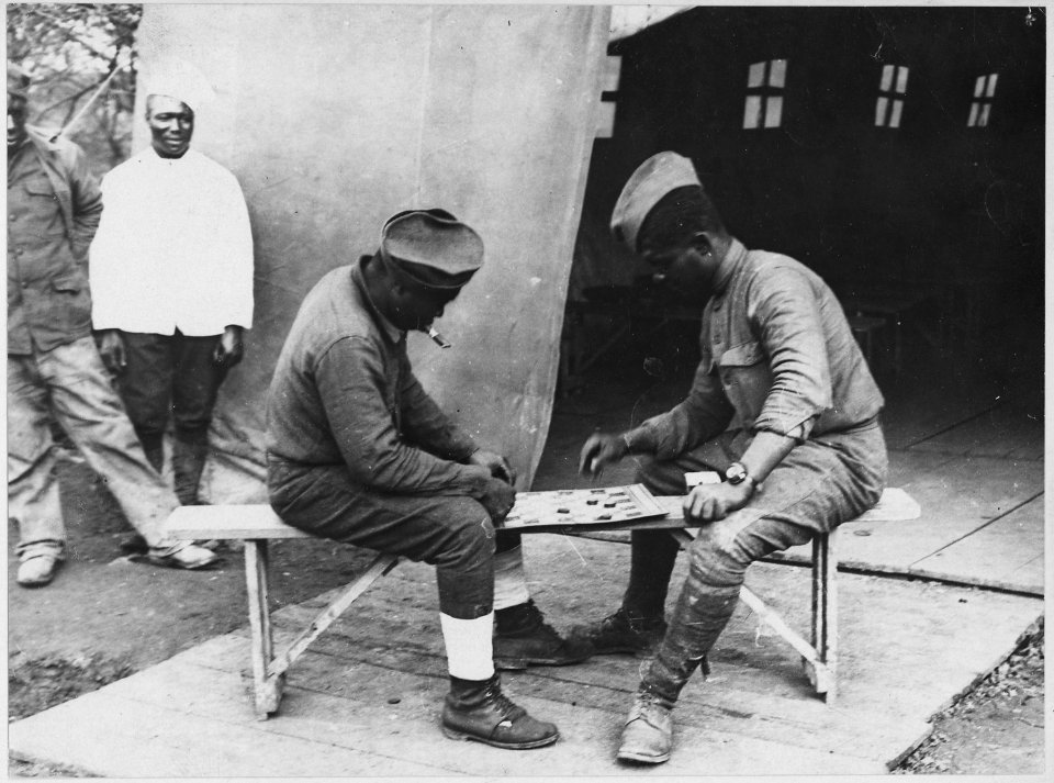 (African American) soldiers in France engaged in a game of checkers in front of a Young Men's Christ . . . - NARA - 533559