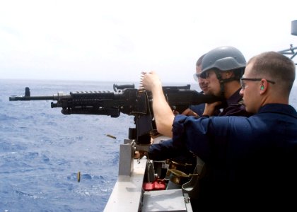 090701-N-1251W-075 - A midshipman from the Japan Maritime Self-Defense Force fires an M-240 machine gun from the bridge wing of the guided-missile cruiser USS Shiloh (CG-67)