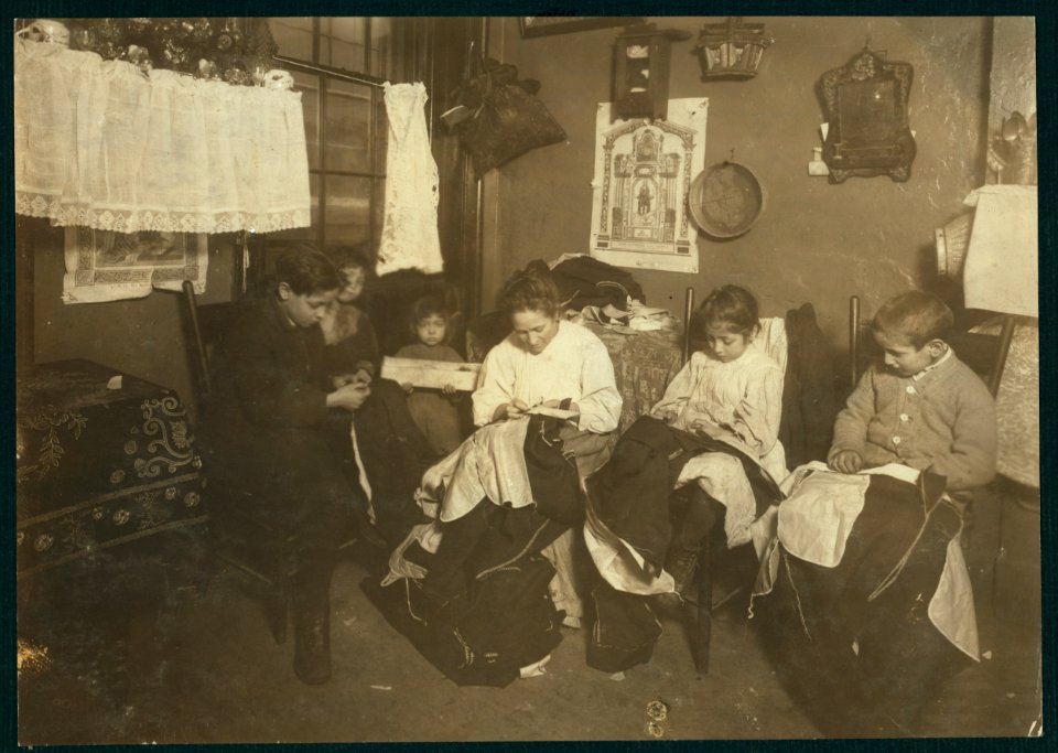 1 P.M. Family of Onofrio Cottone, 7 Extra Pl., N.Y., finishing garments in a terribly run down tenement. The father works on the street. The three oldest children help the mother on LOC nclc.05508