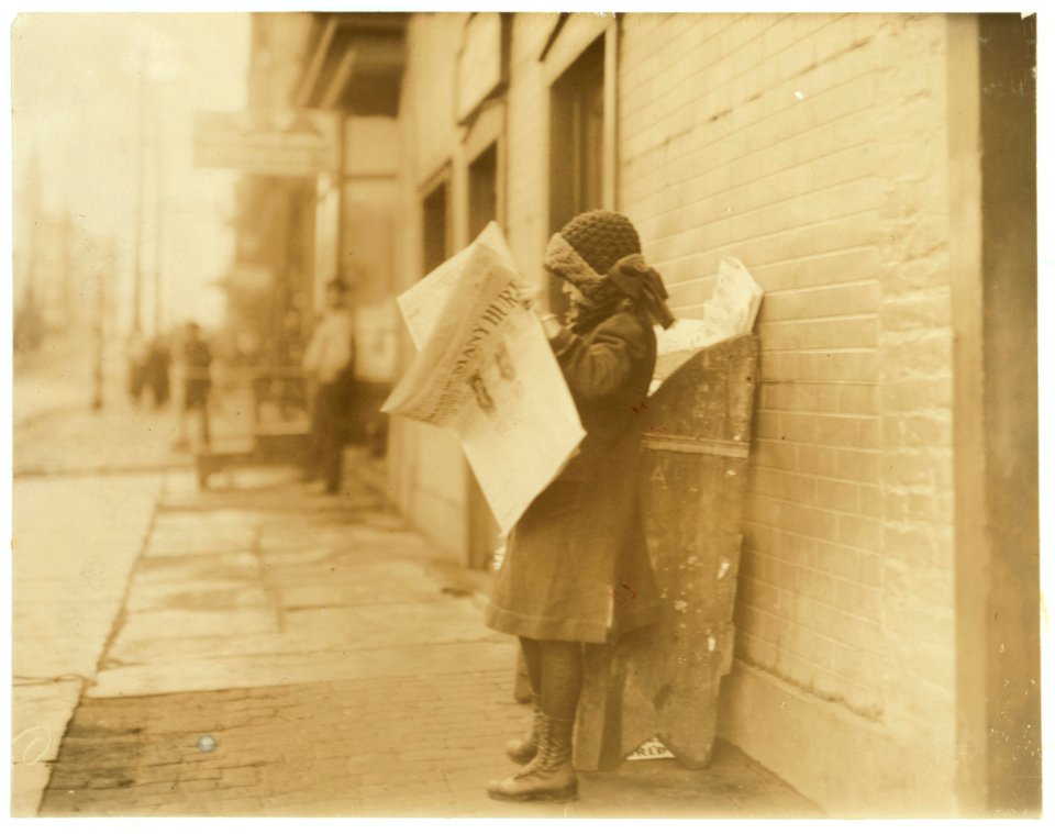 10 yr. old girl tending stand at 4th and Garden Streets. On right is entrance to bar room of saloon. Stand is owned by Mr. Rakoff, whose daughters, 11 yrs and 13 yrs old, take turns, tending LOC nclc.03825