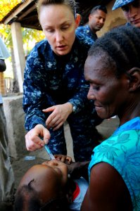 100125-N-8878B-237 - HM2 Alexandra Howard gives medication to a Haitian child as part of continuing relief efforts in Haiti photo