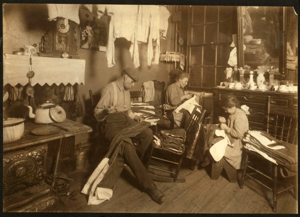 11-30 A.M. Jennie Rizzandi, 9 year old girl, helping mother and father finish garments in a dilapidated tenement, 5 Extra Pl., N.Y.C. They all work until 9 P.M. when busy, and make about $2 LOC cph.3a42529