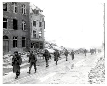 111-SC-236024 - U.S. Inf troops of the 30th Div on march through Malmedy which was leveled in error by U.S. bombers