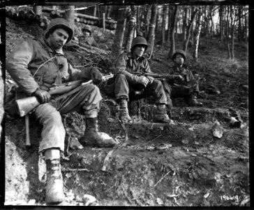 111-SC-196619 - Weary infantrymen take a brief rest on a slope in the Hurtgen forest in Germany. Left to right, Pfc. Maurice Berzon, Buffalo, N.Y., SSgt. Bernard Spurr, Newark, Ohio, and SSgt. Harold Clessler, Ashland, Pa