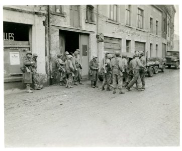 111-SC-329951 - Infantrymen of 1st U.S. Army gather in Bastogne, Belgium, to regroup after being cut away from their regiment by Germans in the enemy drive in this area. 110 Regt, 28th LNE Div FUSA Bastogne, Belgium