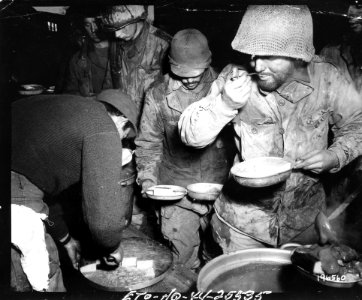 111-SC-19650 - These hungry infantrymen of the 7th Army waste no time when they hear seconds on cake. Bult area, France photo