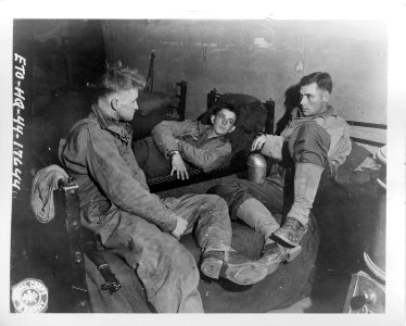 111-SC-401634 - Sgt Alexander McKenzie, Southfield, NC, PFC Chas L. Korenek, Schulenburg, Tex., and Pvt. Henry Nelson, Scarbro, Maine, are shown here enjoying a well earned rest of three days at a rest camp somewhere in Belgium