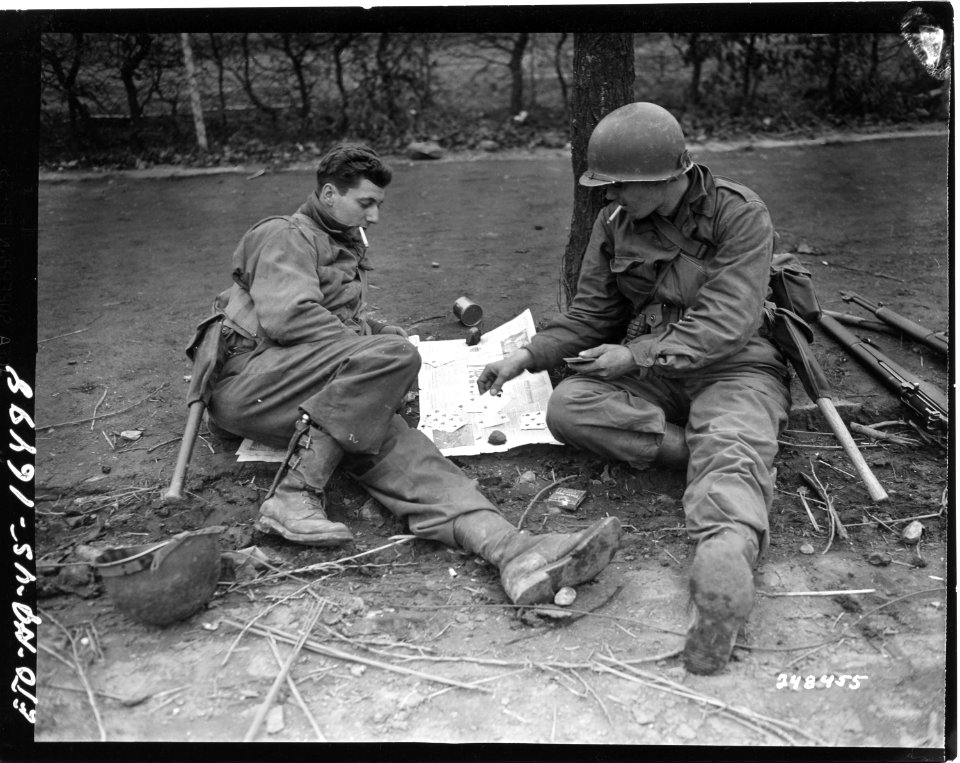 111-SC-248455 - PFC George Cap, from Prior Lake, Minn., and Pvt. James McFarland, of Zanesville, Ohio, both of the 1st Division, U.S. First Army, play cards, as they wait for orders to move out of Vettweiß, Germany