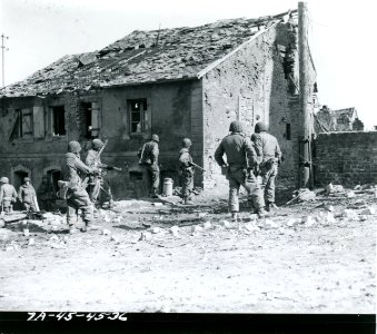 111-SC-270629 - 7th U.S. Army infantrymen of the 7th Inf. Reg prepare to rush house in which Nazi snipers are hidden. Guiderkirch, France photo