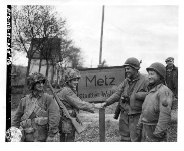 111-SC-411773 - Four infantrymen, members of two patrols that closed the escape gap east of Metz cutting off the escape of the encircled Germans in the town, shake hands after their mission has been accomplished