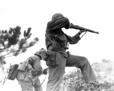 111-SC-337972 - One rifleman reloads, and another fires in the 96th Infantry Division's advance to capture Big Apple Hill, scene of intense fighting on Okinawa