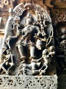 12th-century angry Shakti Devi killing demons at Shaivism Hindu temple Hoysaleswara arts Halebidu Karnataka India photo