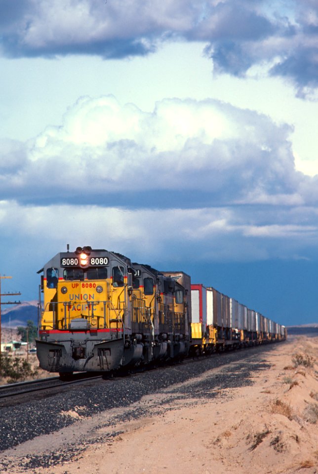 UP 8080 SD40-2H with a westbound train at the Harvard Rd. crossing about 10 mi. east of Yermo, CA in February 1981 (33133589213)