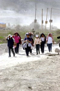 A group of Ecuadorian women covers themselves up from the sun, while traveling a dusty road, leaving the town of Pucara, Ecuador DA-SD-03-08112