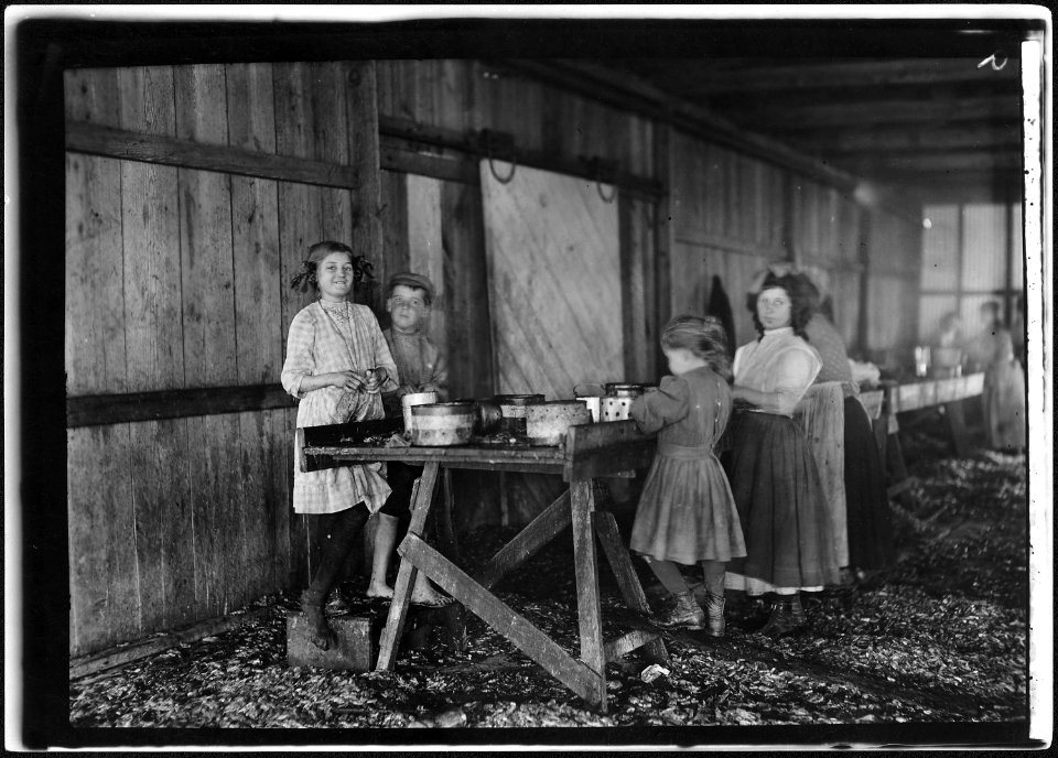 A group of shrimp pickers in Peerless Oyster Co., working during short noon recess. Many workers, including the... - NARA - 523412