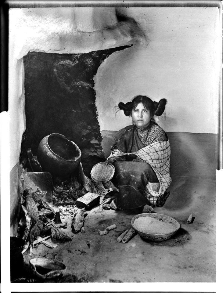 A Hopi maiden drying corn meal at a fireplace at Mishongnovi (Mashonguavi) or Oraibi, Arizona, 1898 (CHS-4587)