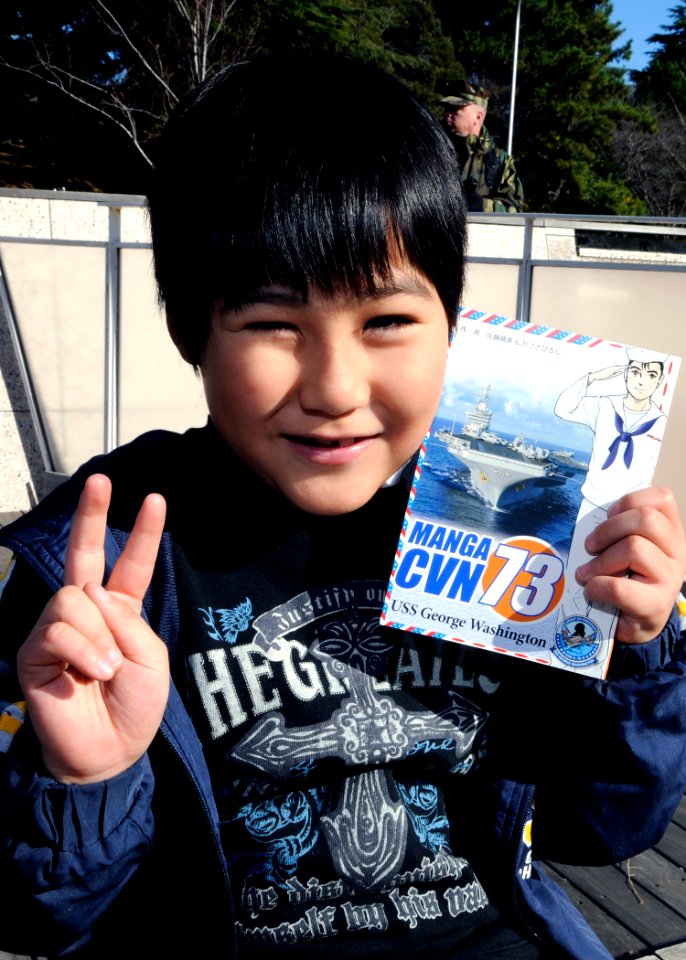 A Japanese boy poses with his copy of Manga CVN 73