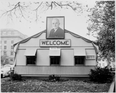 A large photograph of President Harry S. Truman and a Welcome sign beneath it, on the side of the temporary... - NARA - 199952