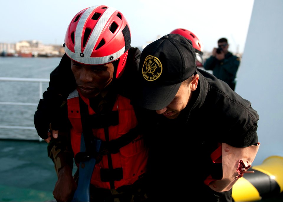 A Liberian coast guardsman, left, assists a Moroccan sailor portraying a casualty during maritime interdiction training aboard the Spanish Civil Guard patrol ship Rio Segura March 9, 2014, in Dakar, Senegal, as 140309-N-QY759-130