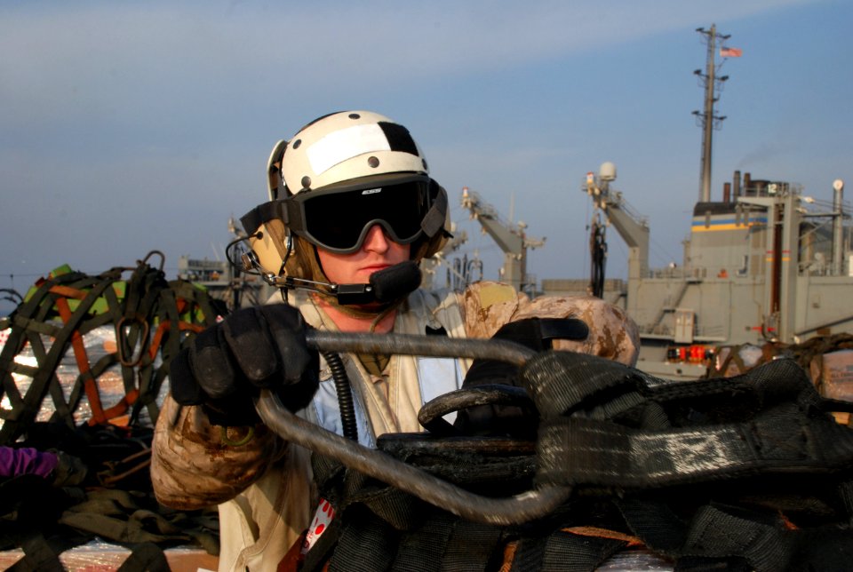 A Marine removes cargo netting aboard USS Green Bay. (8448061432)