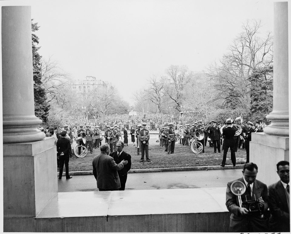 A military band standing on the front lawn of the White House, a large crowd is gathered in Jackson Park across the... - NARA - 199946