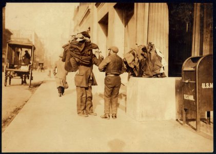 A moment's rest. These bundles are often carried long distances. When the man gets tired, he drops the clothing onto a convenient box or railing, disregarding dust or dirt. Makes button LOC cph.3b01106
