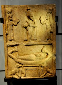 A mummy rests on a sacred boat guarded by Anubis. Above, figures of Osiris, Isis, and Nephthys. Sandstone stela. From Egypt, 332 BCE to 395 CE. Kelvingrove Art Gallery and Museum, Glasgow, UK photo