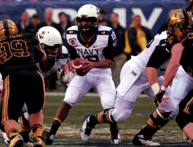 A Navy quaterback steps back from the snap.