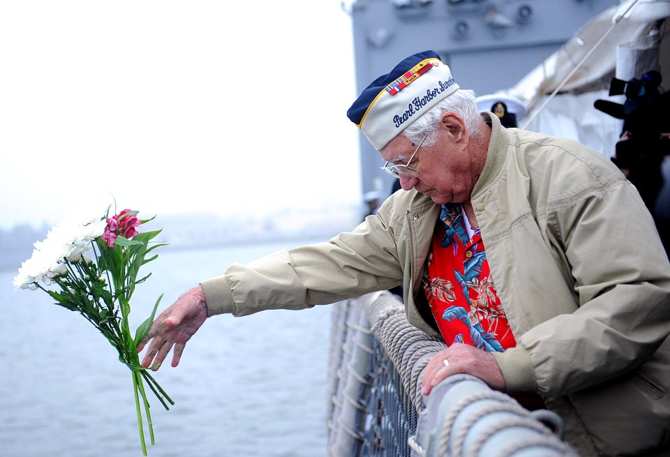A Pearl Harbor survivor tosses flowers. (8264508736)