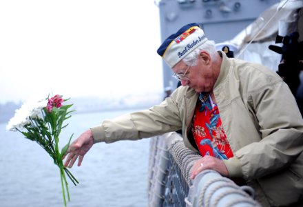A Pearl Harbor survivor tosses flowers. (8264508736)