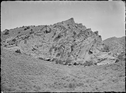 A perpendicular bluff of curiously weathered sandstone opposite the cave. Utah. - NARA - 516939 photo