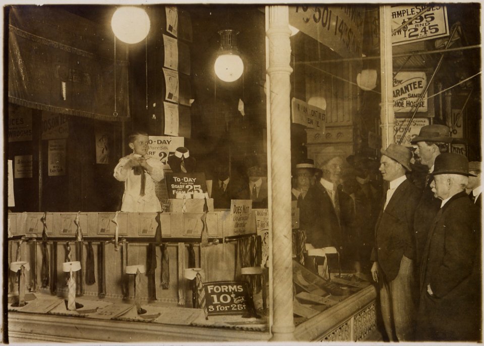 A photograph of 7-year-old Tommie Noonan demonstrating the advantages of the Ideal Necktie Form in a store window on... - NARA - 306614