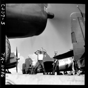 A plane handler giving the signal, Lock tailwheel, to an F6F pilot aboard the USS Tulagi (CVE-72) off the coast of... - NARA - 520859