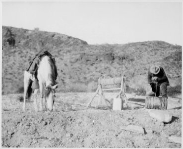 A rider fills his keg from a desert well 30 miles north of Palomas, Ariz. Terr. His horse refreshes himself nearby. By S - NARA - 523019