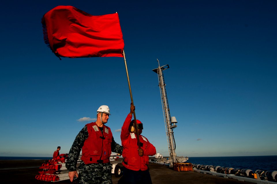 A Sailor carries a reference flag at sea. (8476433676)