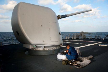 A Sailor cleans a machine gun aboard USS Mobile Bay. (8591441267)