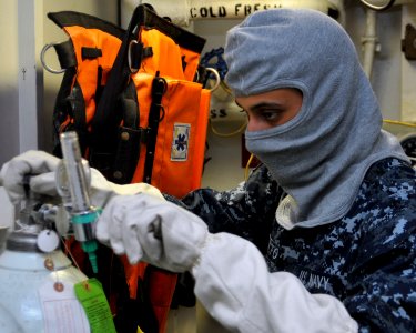 A Sailor checks an oxygen tank. (8455083699)