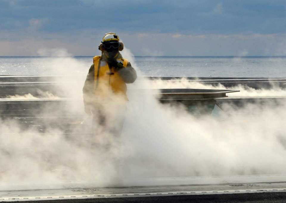 A Sailor crosses the flight deck at sea. (8427153012)