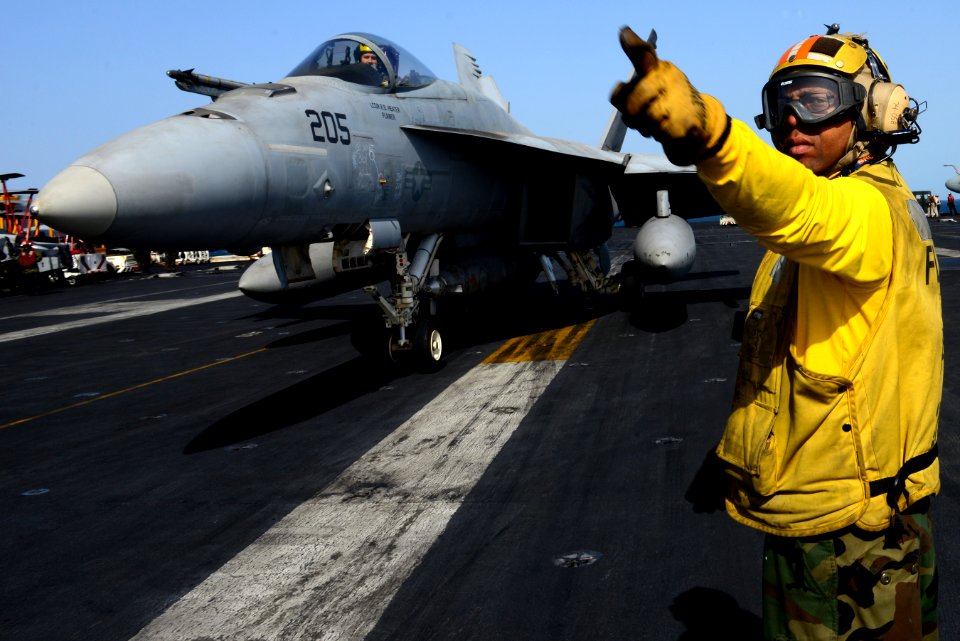 A Sailor directs an F-A-18E at sea. (8408577152)