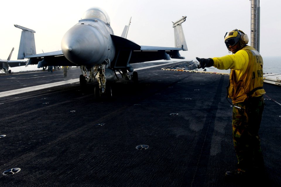 A Sailor directs an F A-18F at sea. (8434689393)