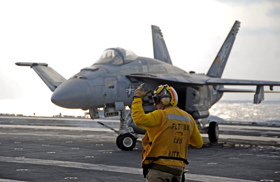 A Sailor directs an F-A-18E. (8189831611)