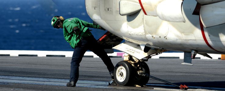 A Sailor checks a C-2A before take off. (8434690627)