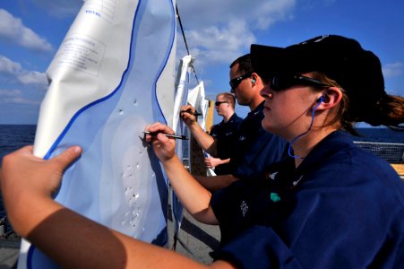 A Sailor counts bullet holes in a target. (8199137663)