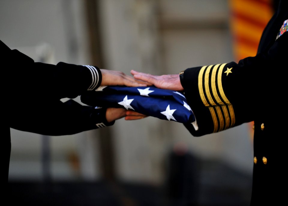 A Sailor hands off a flag during a burial at sea. (8203274860)